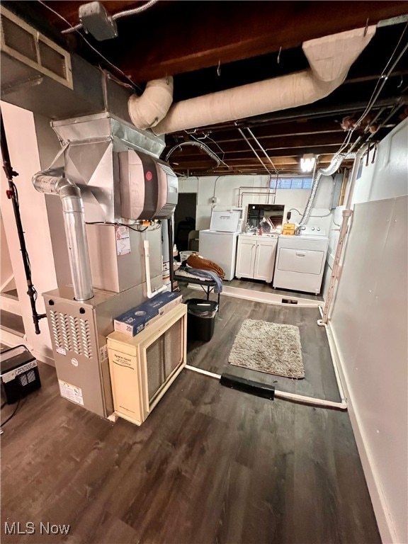 basement with dark hardwood / wood-style floors and washing machine and dryer