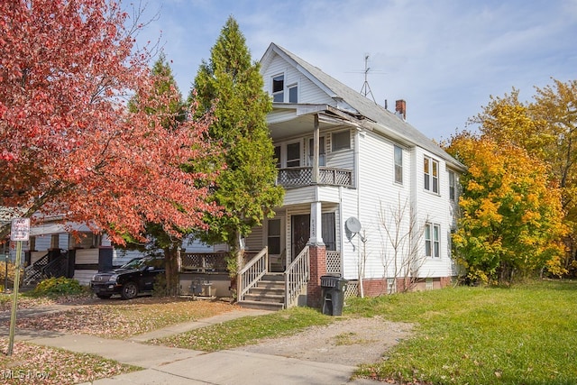 view of front of property featuring a front lawn and a balcony