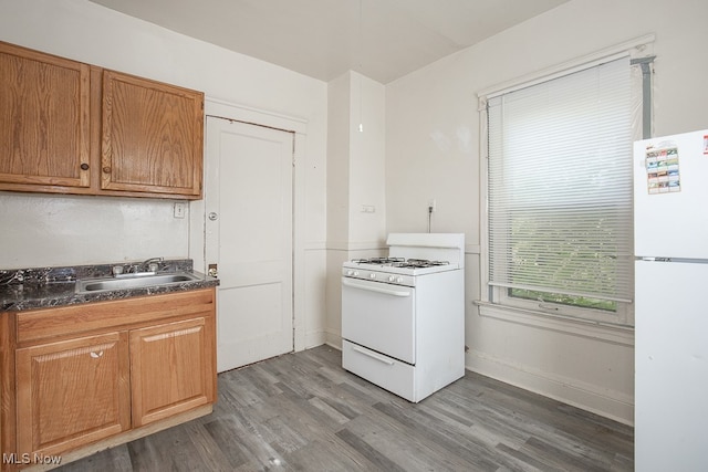 kitchen with sink, dark hardwood / wood-style floors, and white appliances