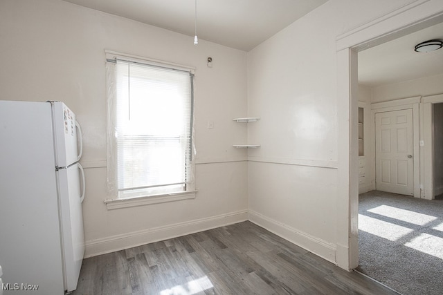 unfurnished dining area featuring dark hardwood / wood-style flooring