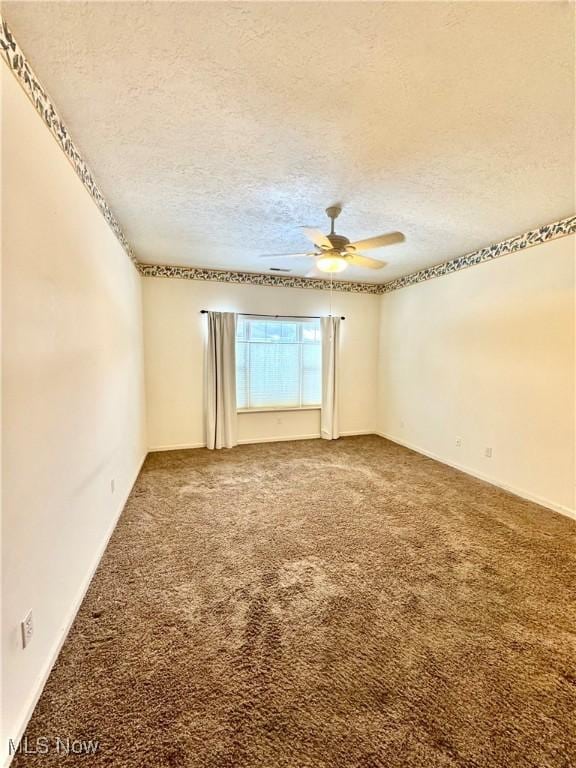 spare room featuring a textured ceiling, ceiling fan, and carpet flooring