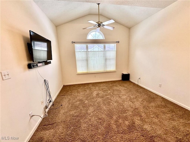 empty room featuring baseboards, a ceiling fan, vaulted ceiling, a textured ceiling, and dark carpet