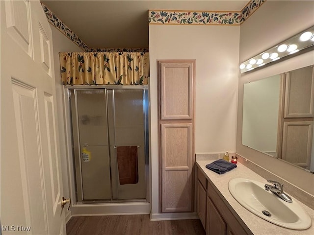 bathroom with a shower stall, wood finished floors, and vanity