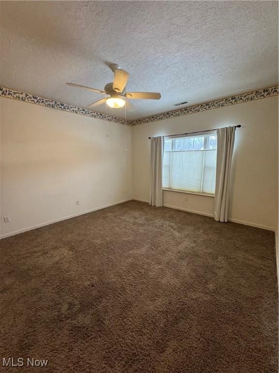 128 Wilcox Rd, Austintown, OH 44515 - empty room featuring visible vents, dark carpet, a ceiling fan, and a textured ceiling