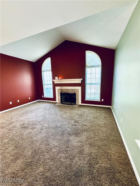 128 Wilcox Rd, Austintown, OH 44515 - unfurnished living room featuring carpet flooring, baseboards, vaulted ceiling, and a fireplace