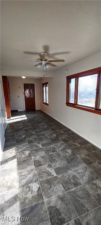 entrance foyer featuring a textured ceiling, a healthy amount of sunlight, and ceiling fan