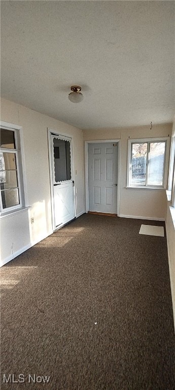 unfurnished room featuring a textured ceiling and carpet