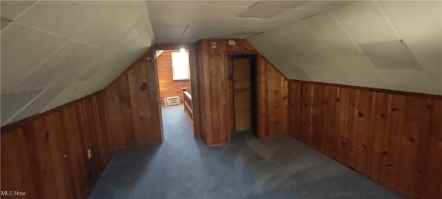 additional living space featuring wood walls, carpet flooring, and lofted ceiling