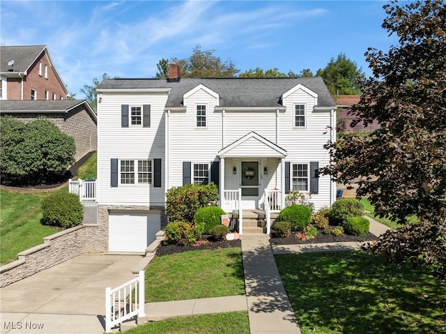 view of front of home with a front lawn, a garage, and covered porch