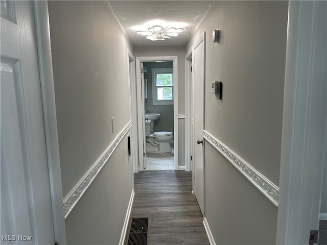 corridor with a textured ceiling and dark hardwood / wood-style flooring