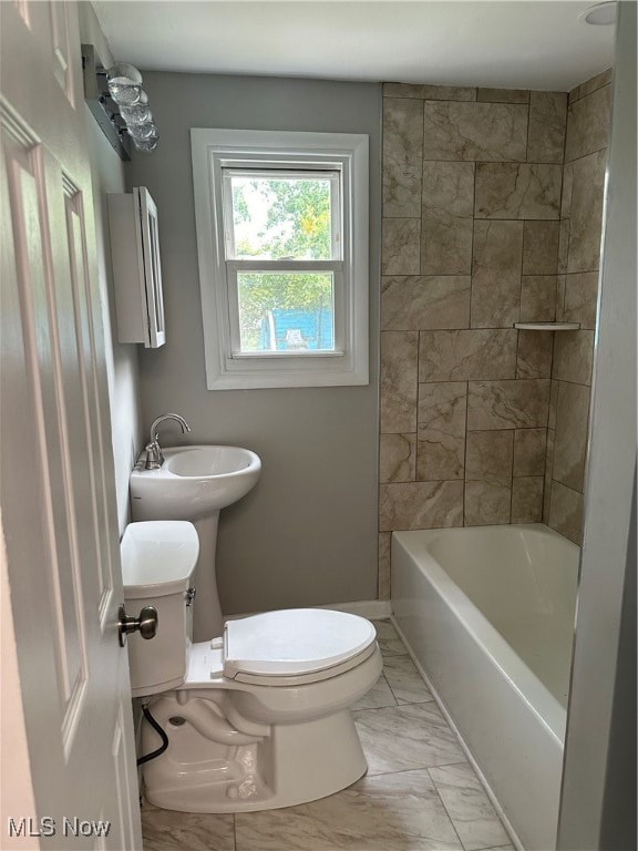 bathroom featuring tiled shower / bath combo and toilet