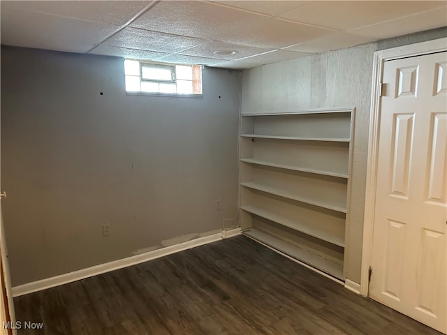 basement featuring dark hardwood / wood-style flooring and a drop ceiling