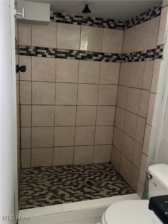 bathroom with toilet and tiled shower