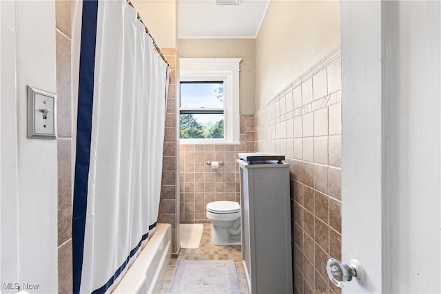 bathroom with tile walls, tile patterned flooring, toilet, and shower / bath combination with curtain