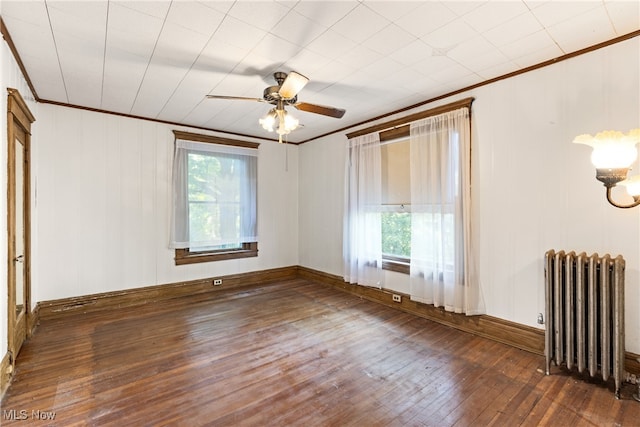 spare room with radiator heating unit, ceiling fan, crown molding, and dark hardwood / wood-style flooring