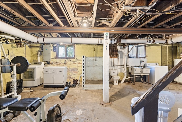 basement featuring electric panel, water heater, sink, and washing machine and clothes dryer