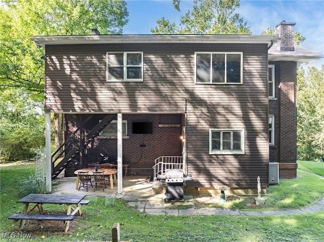 rear view of property with a yard and a patio area