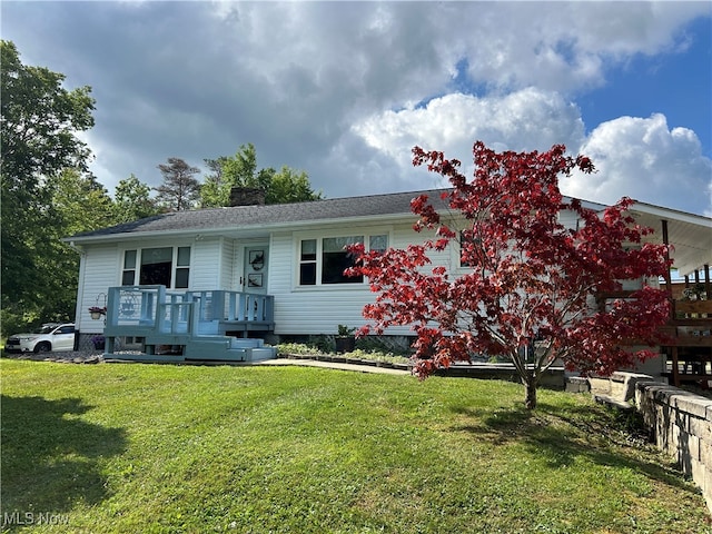 view of front of home with a front yard and a deck