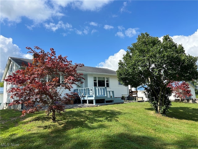 back of house with a lawn and a deck