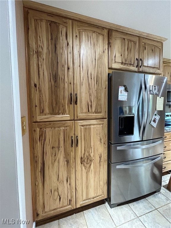 kitchen with stainless steel refrigerator with ice dispenser and light tile patterned floors