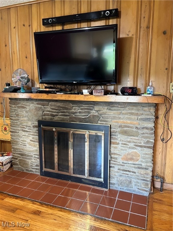 details with a fireplace, hardwood / wood-style flooring, and wood walls