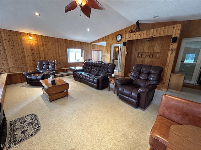 carpeted living room with a baseboard heating unit, vaulted ceiling, a textured ceiling, wooden walls, and ceiling fan