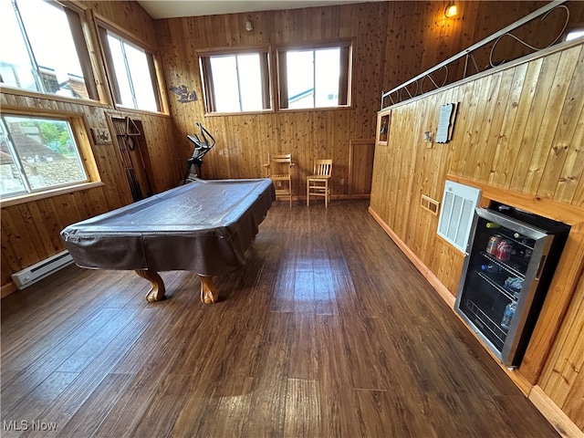 game room featuring wood walls, a towering ceiling, beverage cooler, and dark hardwood / wood-style flooring