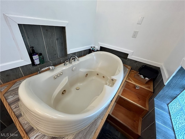 bathroom with a tub to relax in and sink