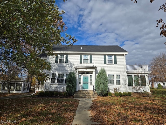 view of front of home with a sunroom and a balcony