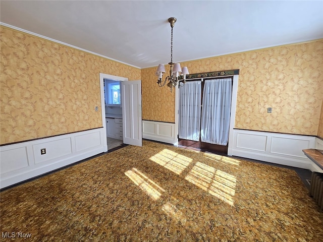 empty room featuring ornamental molding and an inviting chandelier