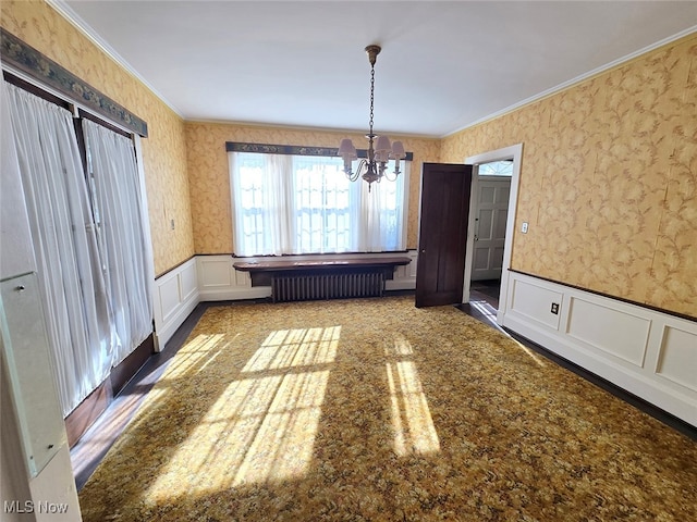 unfurnished dining area with ornamental molding, radiator heating unit, and a notable chandelier