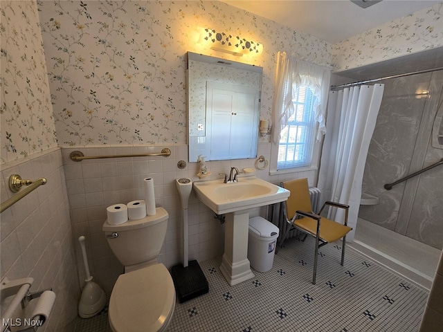 bathroom featuring curtained shower, tile patterned floors, toilet, and tile walls