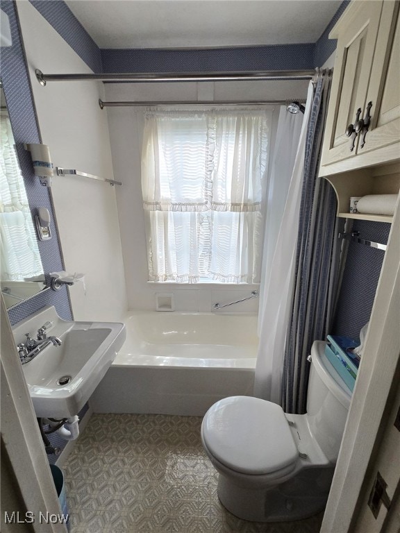 full bathroom with shower / bath combo with shower curtain, toilet, and sink