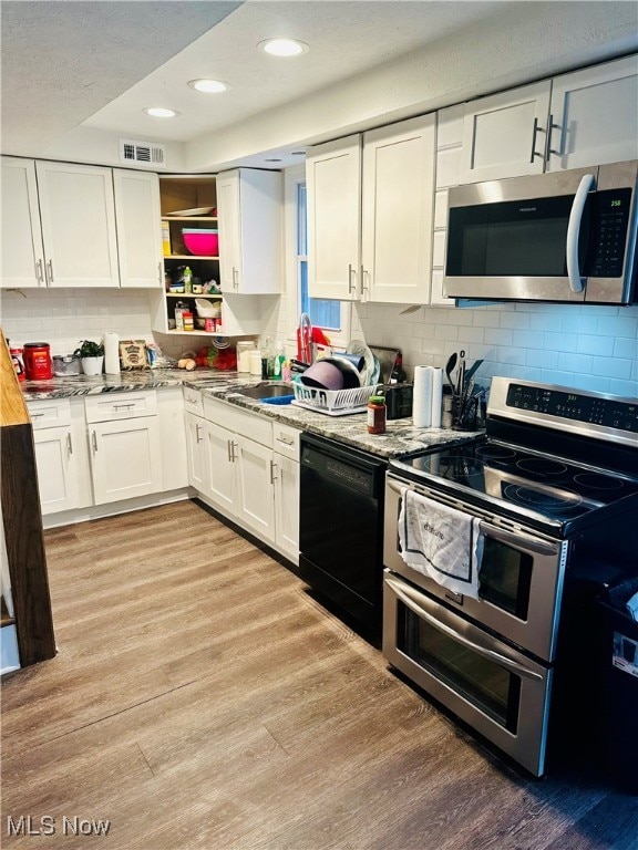 kitchen featuring decorative backsplash, light hardwood / wood-style floors, white cabinetry, and stainless steel appliances