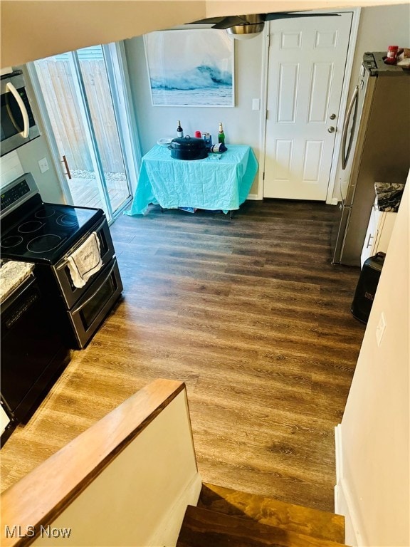 bedroom with stainless steel refrigerator and wood-type flooring