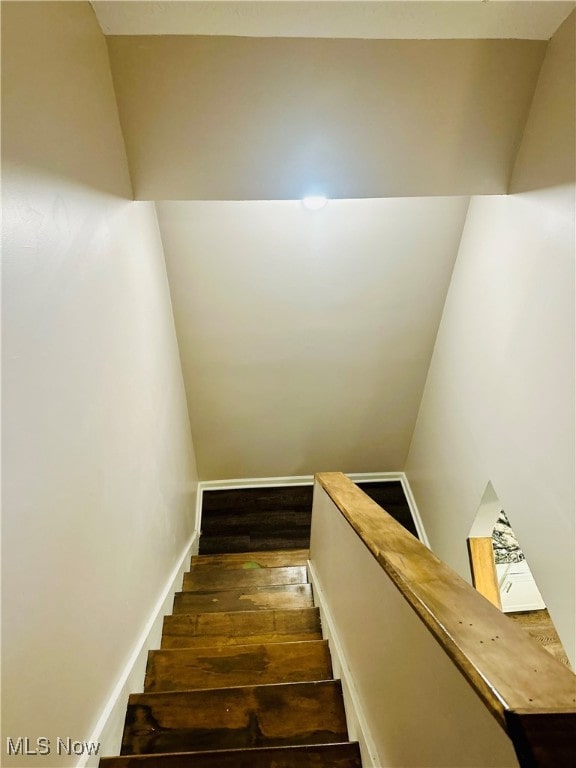 stairway with hardwood / wood-style floors and lofted ceiling