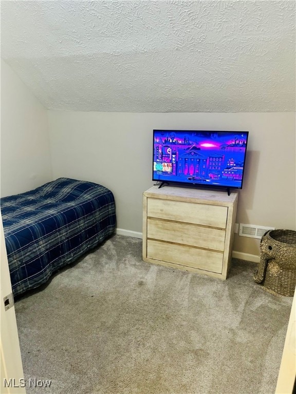 bedroom with carpet flooring, a textured ceiling, and vaulted ceiling