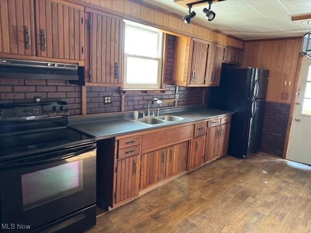 kitchen with a healthy amount of sunlight, sink, black appliances, and light hardwood / wood-style floors