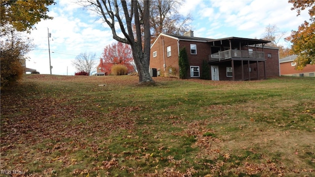 view of yard with central air condition unit and a balcony