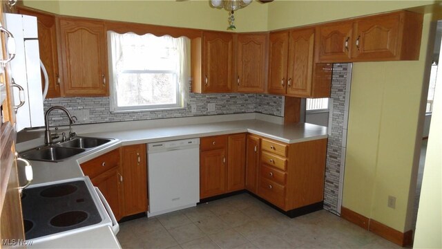 130 Clearview Ave, Weirton, WV 26062 - kitchen with dishwasher, stove, decorative backsplash, brown cabinetry, and light countertops