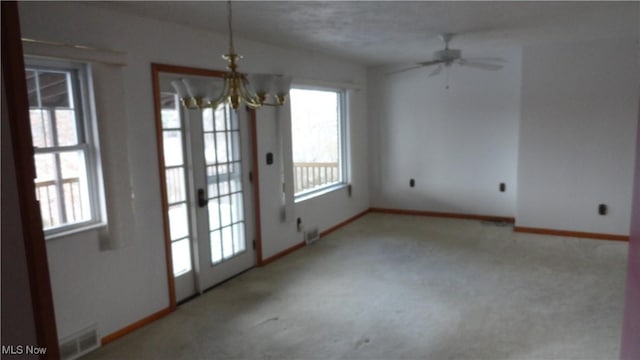 interior space featuring light carpet, a textured ceiling, and ceiling fan with notable chandelier