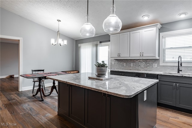 kitchen featuring a textured ceiling, sink, and pendant lighting