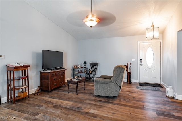 foyer with dark wood-type flooring, vaulted ceiling, and ceiling fan with notable chandelier