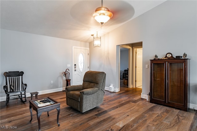 sitting room with dark hardwood / wood-style flooring and lofted ceiling