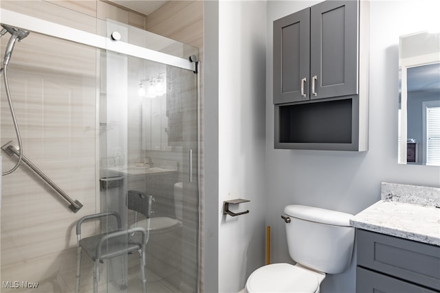 bathroom featuring walk in shower, vanity, and toilet