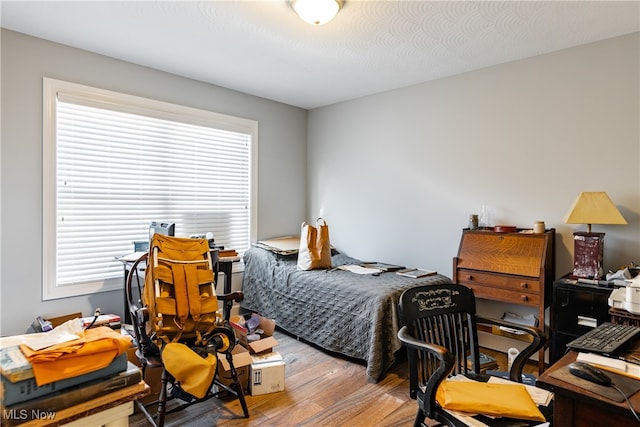 bedroom with a textured ceiling and light hardwood / wood-style flooring