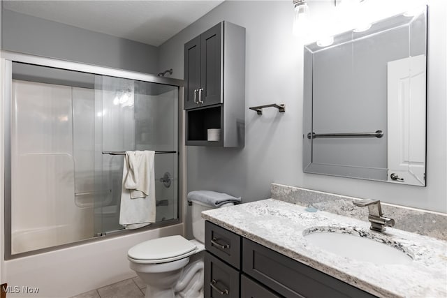 full bathroom with toilet, bath / shower combo with glass door, tile patterned flooring, a textured ceiling, and vanity