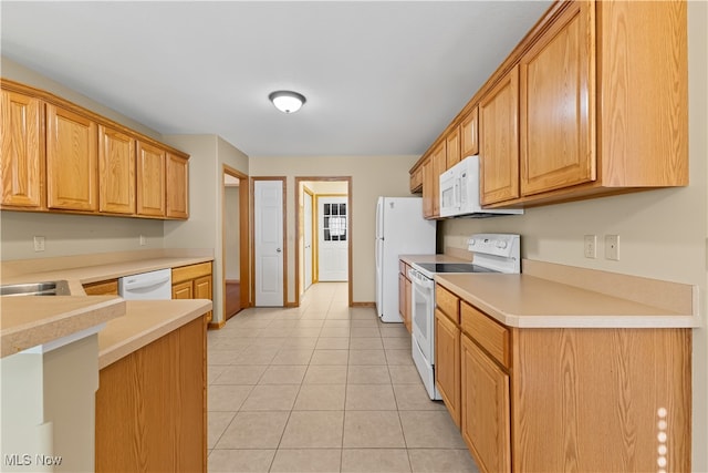 kitchen featuring light tile patterned flooring and white appliances