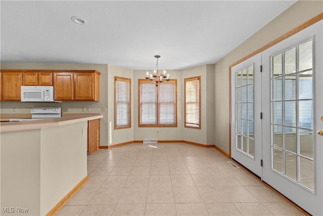 kitchen featuring range, a wealth of natural light, decorative light fixtures, and a notable chandelier