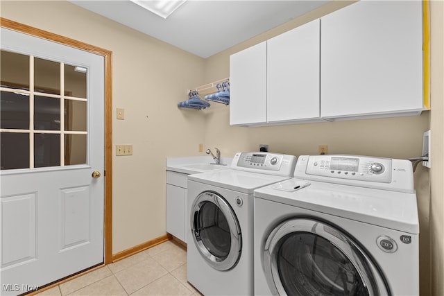 laundry area featuring washer and clothes dryer, cabinets, light tile patterned floors, and sink